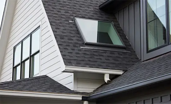 Fixed Skylight Systems installed in a home. The image shows a modern home with a sleek roofline, featuring several fixed skylights that allow natural light to flood the interior spaces. The skylights are seamlessly integrated into the roof, enhancing the home's aesthetic while providing abundant daylight inside.